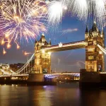 Fireworks illuminating the night sky over Tower Bridge in London, creating a vibrant and celebratory atmosphere for the New Year.